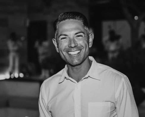 Nader Kazemi smiling in a black-and-white portrait